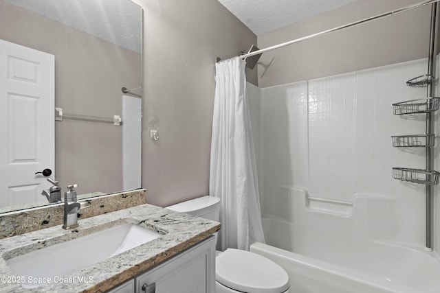 full bathroom featuring shower / bath combo with shower curtain, vanity, toilet, and a textured ceiling