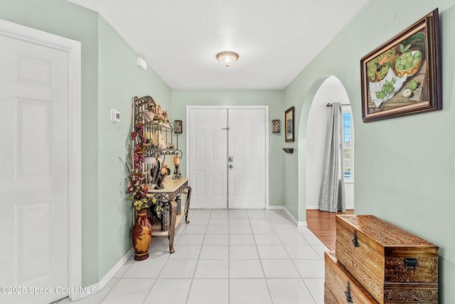 foyer with light tile patterned flooring and a textured ceiling