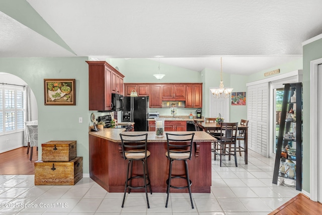 kitchen with black appliances, pendant lighting, kitchen peninsula, and light tile patterned floors