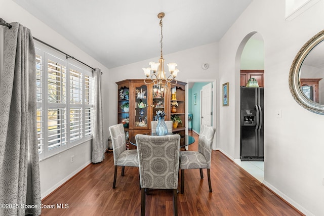 dining space featuring a chandelier, hardwood / wood-style flooring, and lofted ceiling