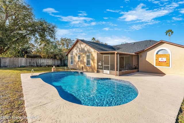 view of swimming pool featuring a sunroom, a yard, and a patio