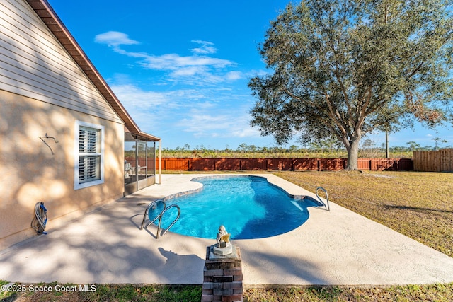 view of pool with a patio and a lawn