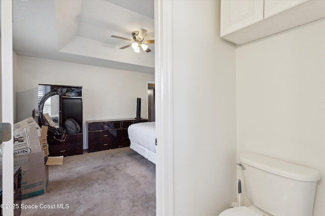 bedroom with a tray ceiling, ceiling fan, and light colored carpet