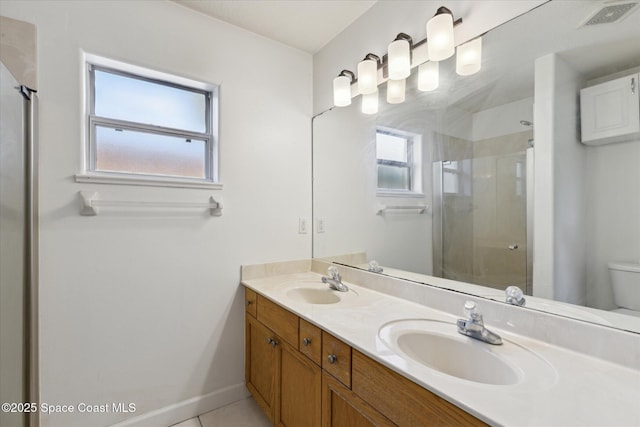 bathroom with an enclosed shower, vanity, toilet, and tile patterned floors