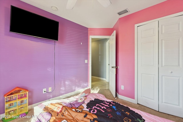 carpeted bedroom featuring ceiling fan and a closet