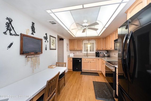 kitchen with light brown cabinetry, light hardwood / wood-style floors, black appliances, ceiling fan, and sink