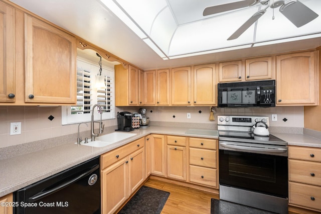 kitchen with sink, light brown cabinets, light hardwood / wood-style flooring, backsplash, and black appliances