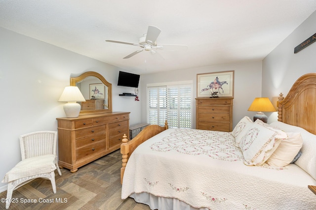 bedroom with ceiling fan and dark parquet flooring