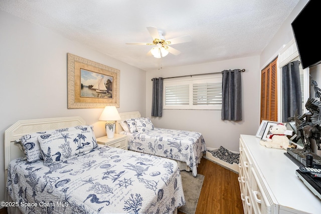 bedroom with hardwood / wood-style flooring, a textured ceiling, and ceiling fan