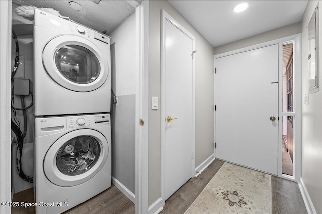 laundry area featuring dark hardwood / wood-style floors and stacked washer / drying machine