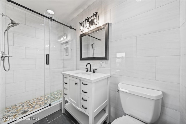 bathroom featuring vanity, toilet, tile walls, and walk in shower