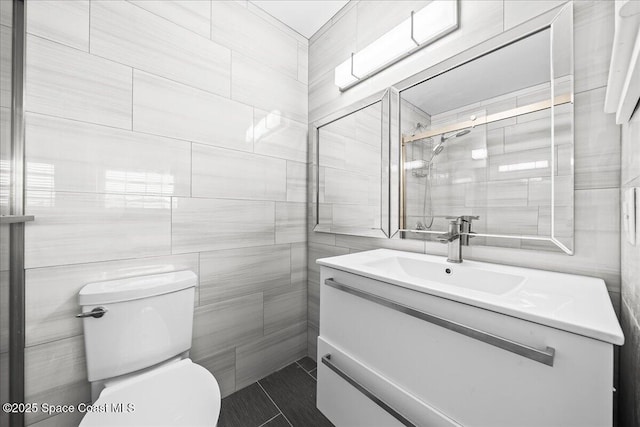 bathroom with vanity, toilet, and tile walls