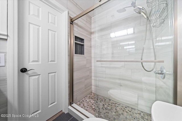 bathroom featuring toilet and an enclosed shower