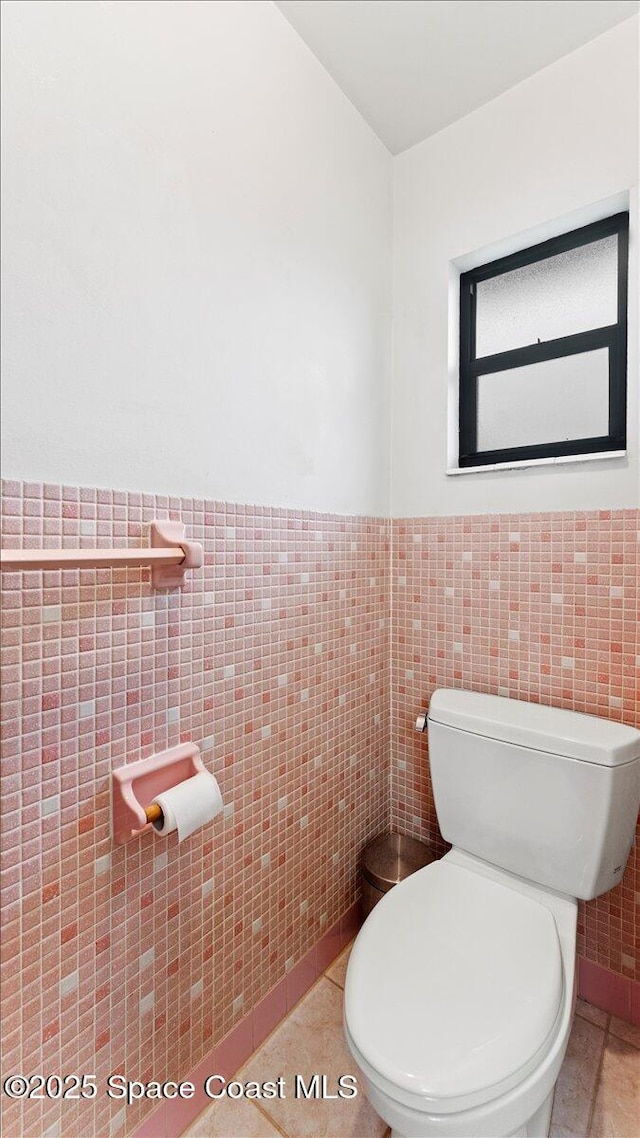 bathroom featuring tile walls, toilet, and tile patterned flooring