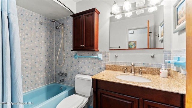 full bathroom with vanity, toilet, tile walls, and tiled shower / bath