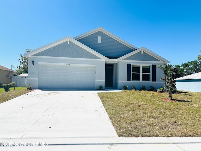 view of front of property with driveway, a front lawn, an attached garage, and fence