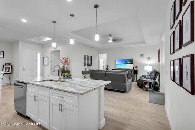 kitchen with pendant lighting, white cabinetry, a raised ceiling, and sink