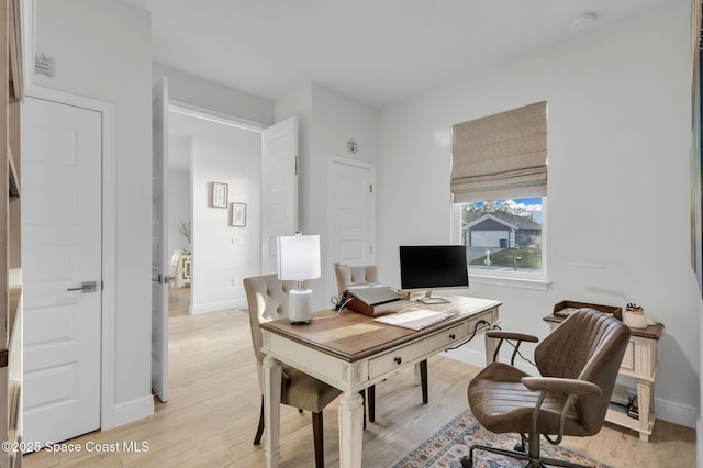 home office with light hardwood / wood-style floors