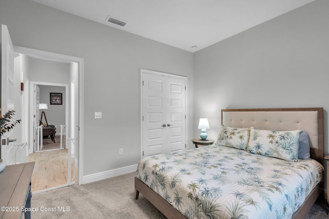 bedroom with light carpet and a closet