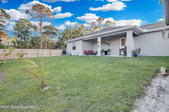 rear view of property with a yard and cooling unit