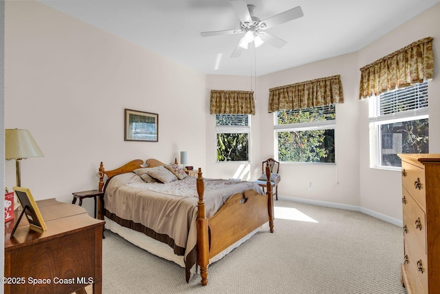 bedroom featuring ceiling fan, light colored carpet, and multiple windows