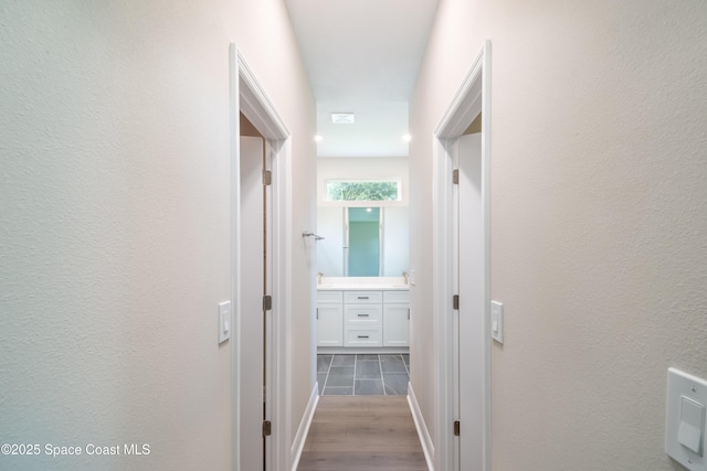 corridor featuring light hardwood / wood-style flooring and sink