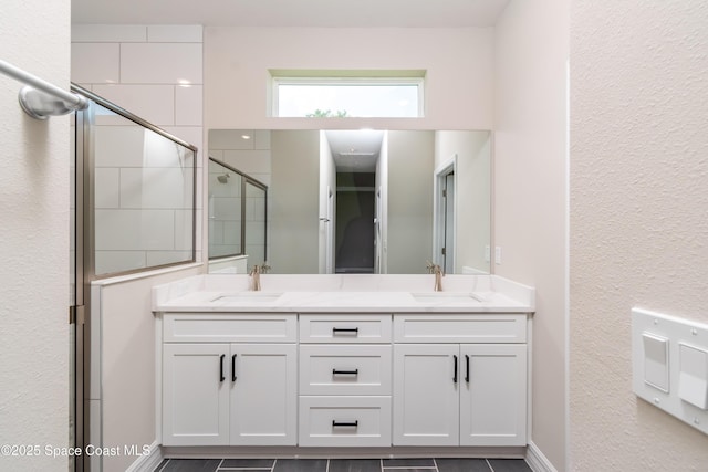 bathroom with a shower with door, vanity, and tile patterned flooring