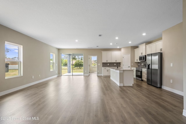 228 Dunlap Ave SE, Palm Bay, FL 32909 - kitchen featuring appliances with stainless steel finishes, a sink, a kitchen island with sink, baseboards, and open floor plan