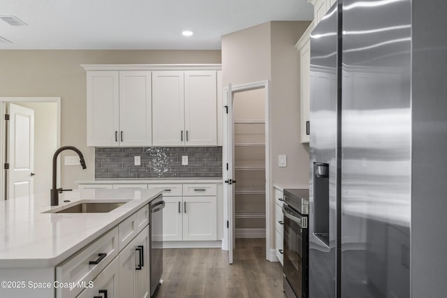 228 Dunlap Ave SE, Palm Bay, FL 32909 - kitchen with a sink, appliances with stainless steel finishes, white cabinets, and wood finished floors