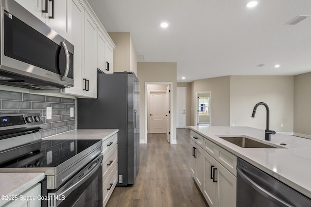 228 Dunlap Ave SE, Palm Bay, FL 32909 - kitchen featuring a sink, stainless steel appliances, white cabinetry, decorative backsplash, and visible vents