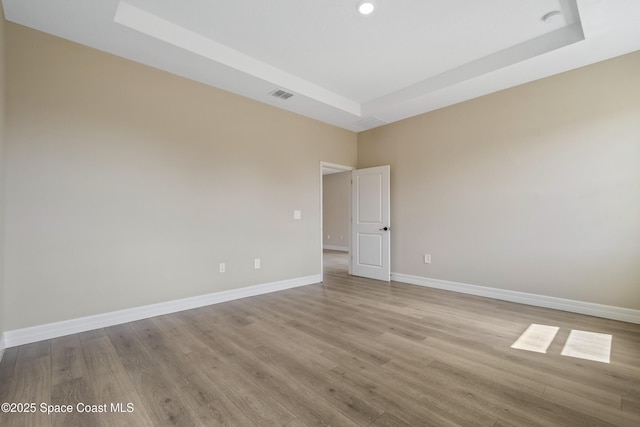 228 Dunlap Ave SE, Palm Bay, FL 32909 - unfurnished room featuring visible vents, baseboards, wood finished floors, and a tray ceiling
