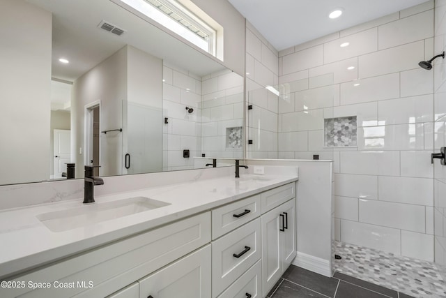 228 Dunlap Ave SE, Palm Bay, FL 32909 - bathroom featuring double vanity, visible vents, tile patterned flooring, a sink, and tiled shower