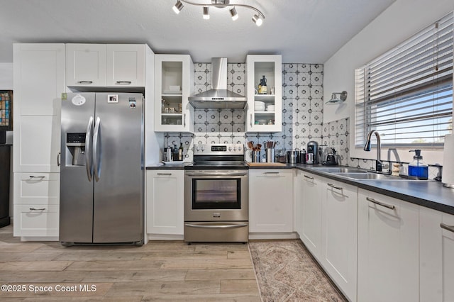 kitchen with white cabinetry, sink, stainless steel appliances, wall chimney range hood, and a textured ceiling