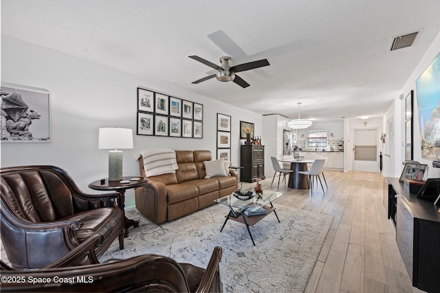 living room with ceiling fan and light hardwood / wood-style flooring