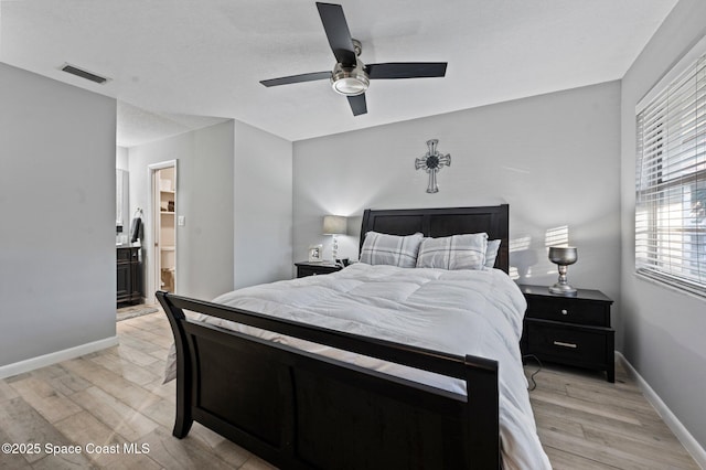 bedroom featuring light hardwood / wood-style floors, ensuite bath, and ceiling fan