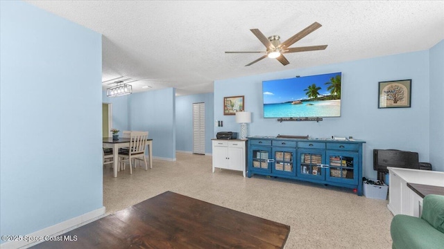 living room with a textured ceiling and ceiling fan