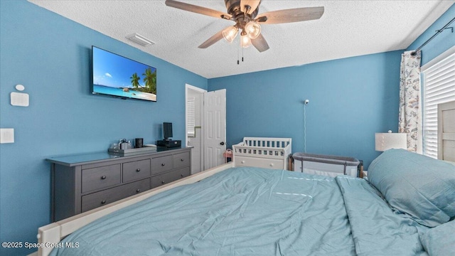 bedroom featuring ceiling fan and a textured ceiling