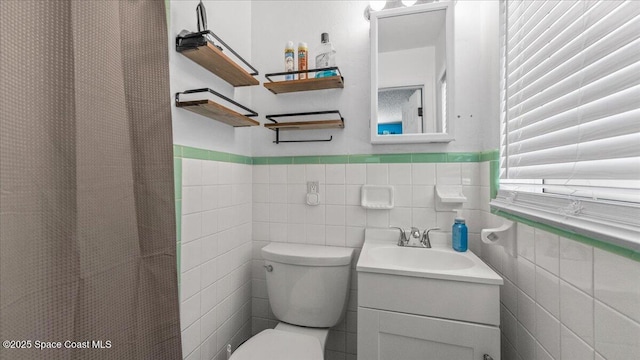 bathroom with vanity, curtained shower, toilet, and tile walls