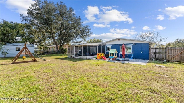 view of yard featuring a sunroom, a patio area, and a playground