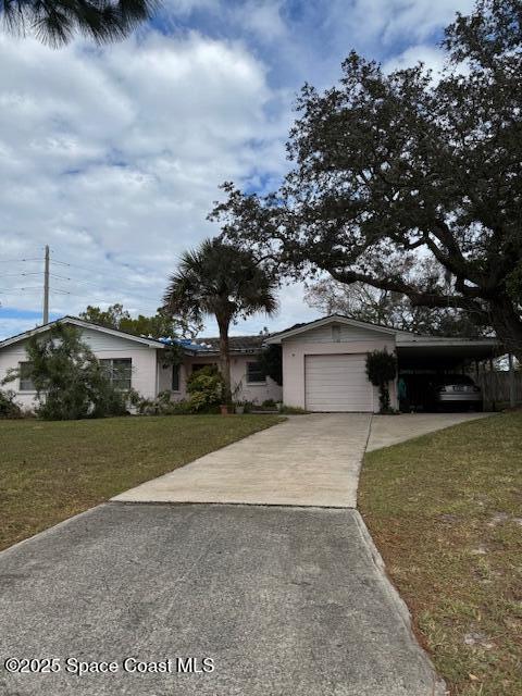 ranch-style house featuring a front yard, a garage, and a carport