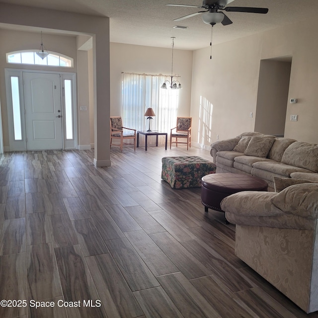 living room featuring ceiling fan with notable chandelier