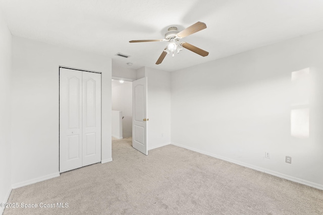 unfurnished bedroom with light colored carpet, ceiling fan, and a closet