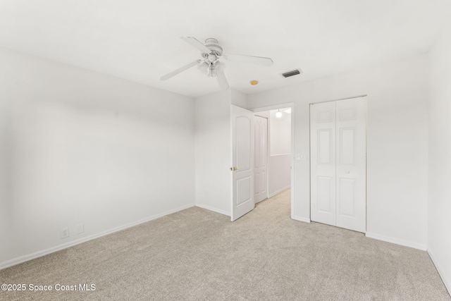 unfurnished bedroom with light carpet, ceiling fan, and a closet