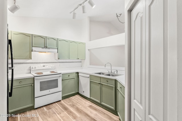 kitchen featuring tasteful backsplash, sink, green cabinets, white appliances, and light hardwood / wood-style flooring