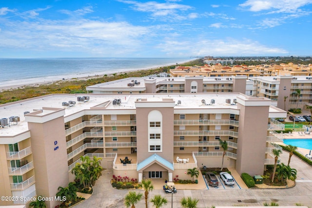 view of building exterior with a water view and a beach view