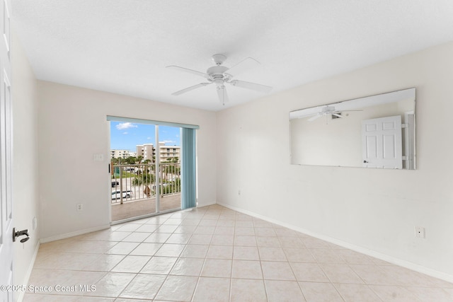 tiled empty room featuring ceiling fan and a textured ceiling