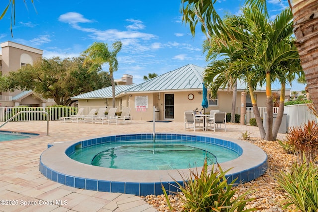 view of swimming pool with a hot tub and a patio area