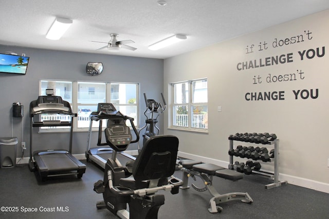 gym with ceiling fan and a textured ceiling