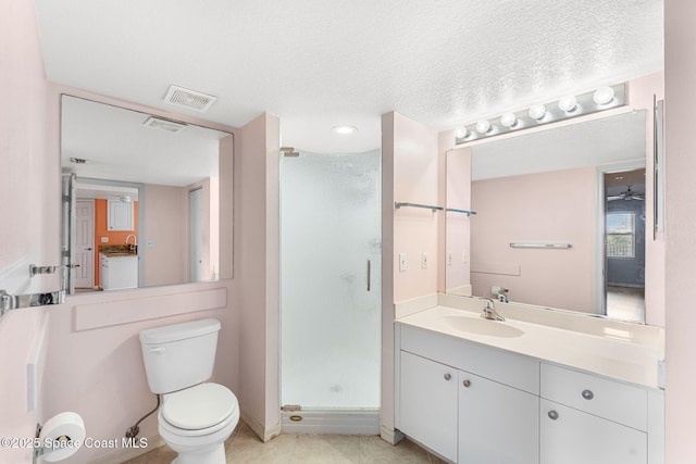 bathroom with a textured ceiling, vanity, ceiling fan, toilet, and a shower with shower door