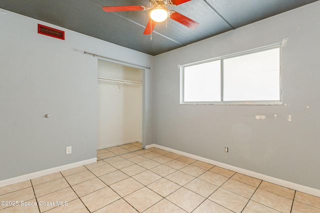 unfurnished bedroom with ceiling fan and a closet